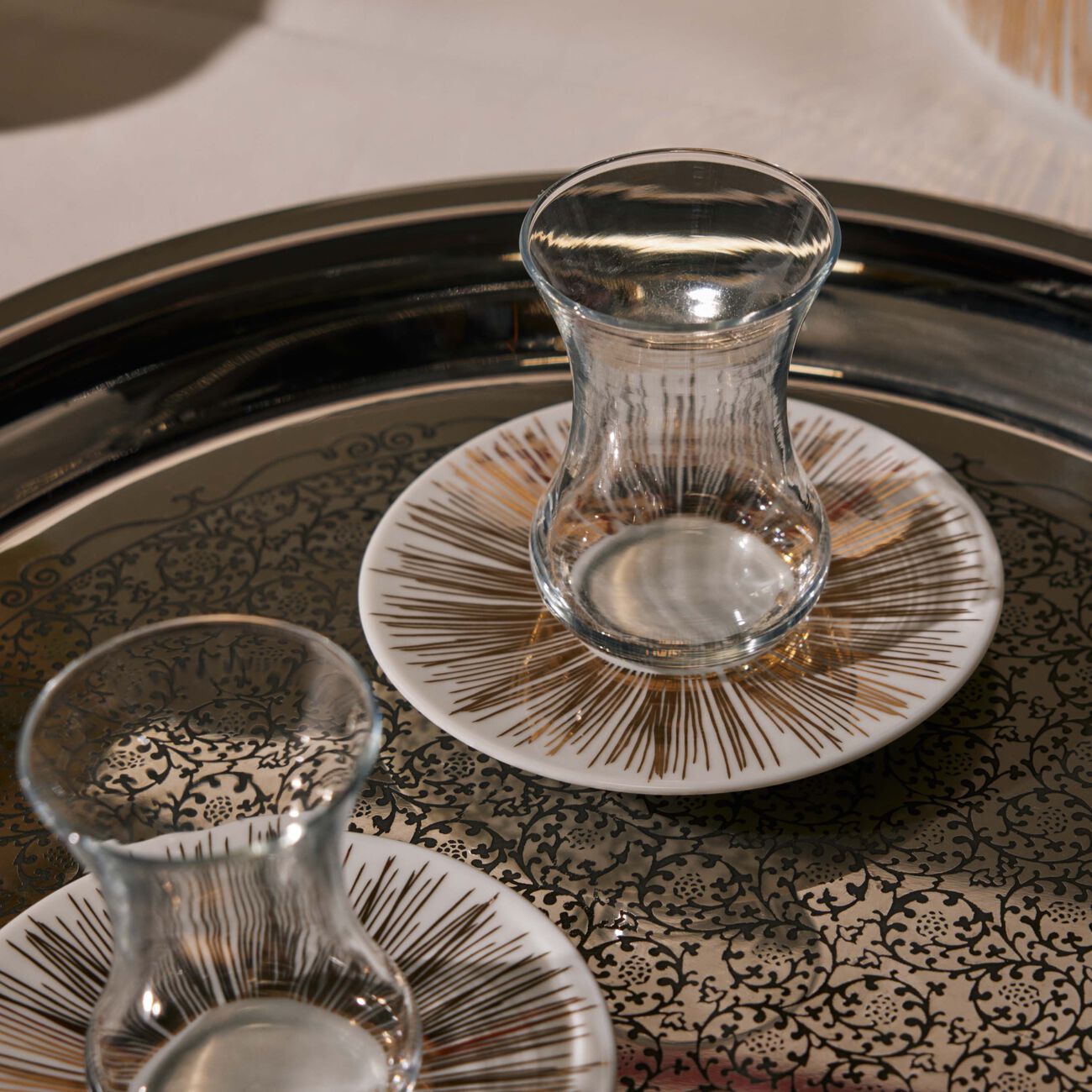 صلصال طقم تمرة بالتعاون مع رزان العزوني سترايبس المؤلف من فنجانين عربيين للشاي مع صحنيهما باللون الذهبي