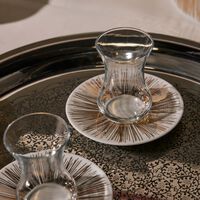 صلصال طقم تمرة بالتعاون مع رزان العزوني سترايبس المؤلف من فنجانين عربيين للشاي مع صحنيهما باللون الذهبي