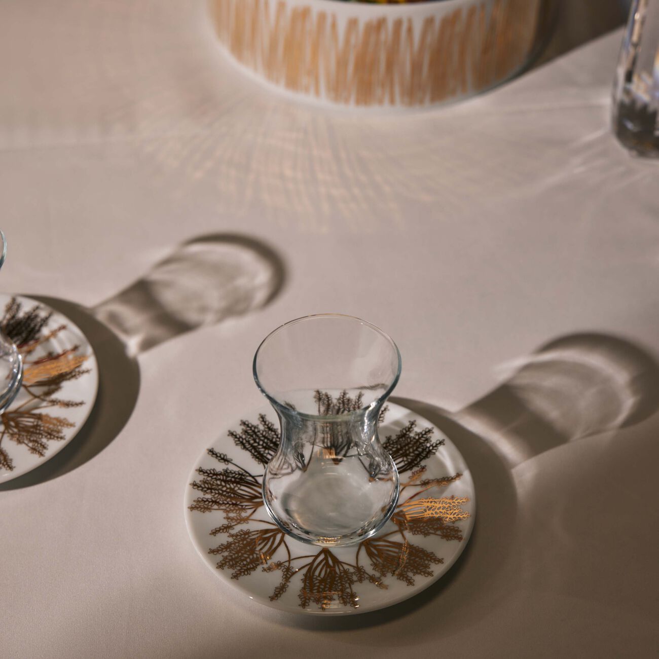 صلصال طقم تمرة بالتعاون مع رزان العزوني برانش المؤلف من فنجانين عربيين للشاي مع صحنيهما باللون الذهبي